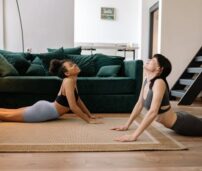 Dos chicas estudiates haciendo yoga en su piso alquilado