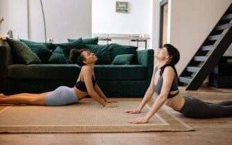 Dos chicas estudiates haciendo yoga en su piso alquilado