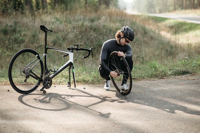 Hombre reparando su bicicleta de carretera