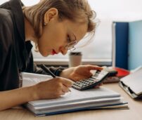 Mujer haciendo cálculos para ver su situación económica y ver cuanto ahorra