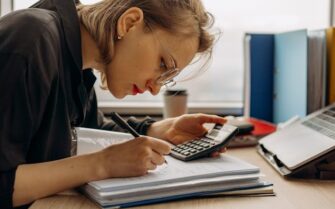 Mujer haciendo cálculos para ver su situación económica y ver cuanto ahorra