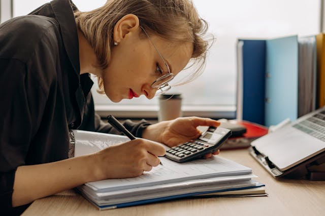 Mujer haciendo cálculos para ver su situación económica y ver cuanto ahorra