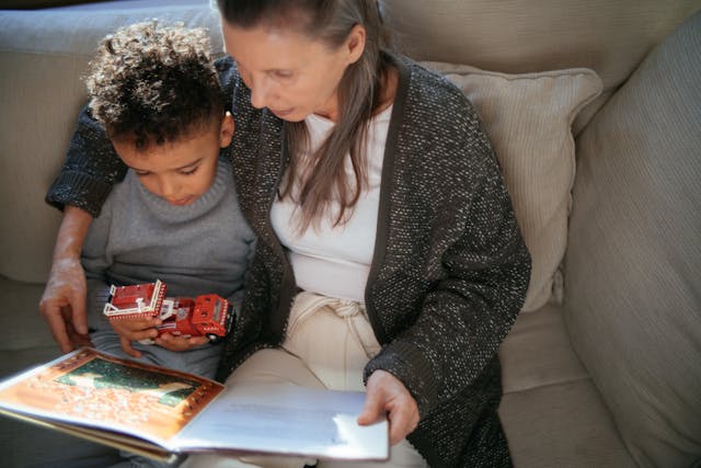 Niño en casa leyendo con su familia